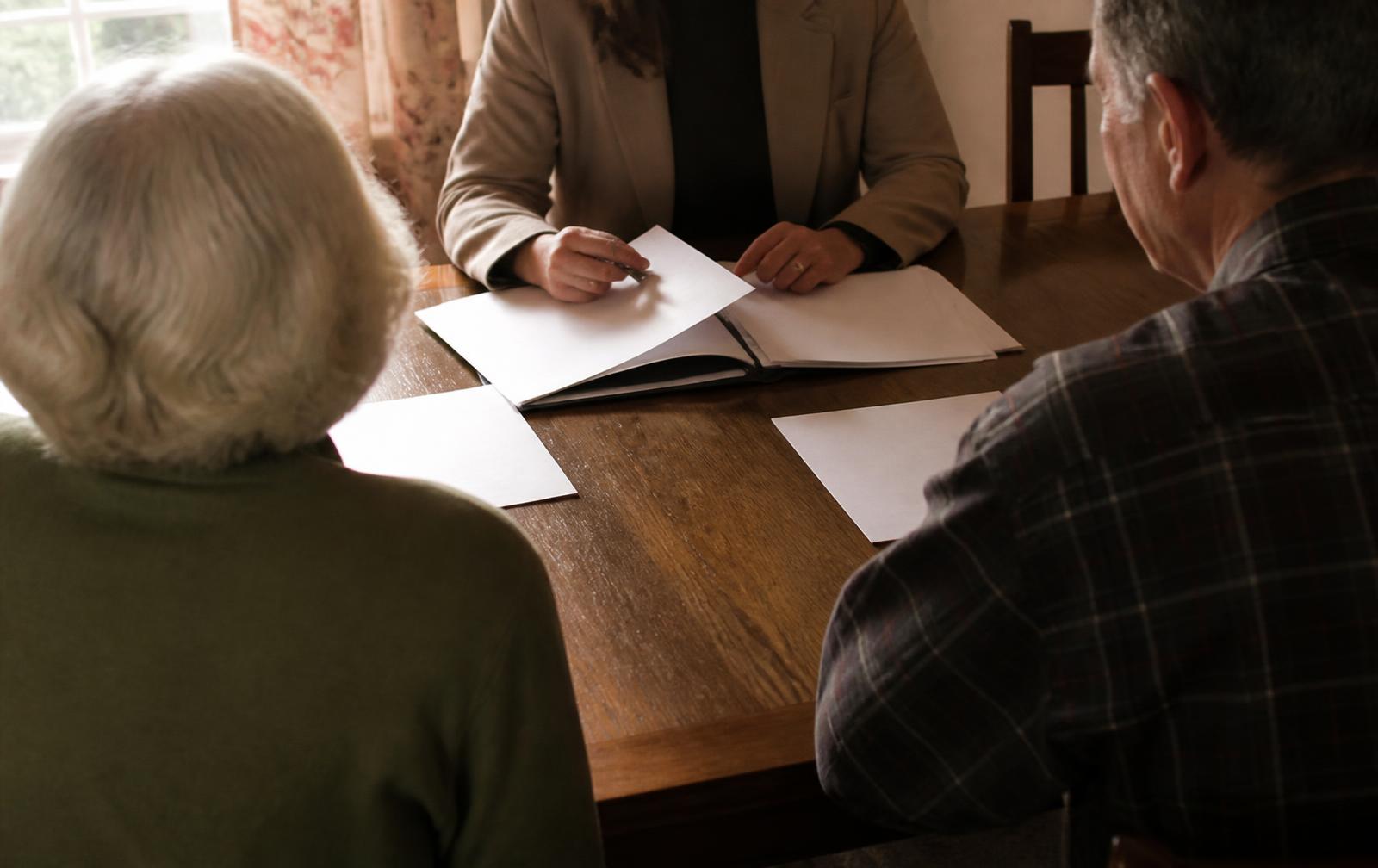 Placement advisor reviewing housing options and paperwork with a family at a dining table